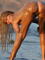 long haired blonde gets down and dirty in the sand in the mud and sun.